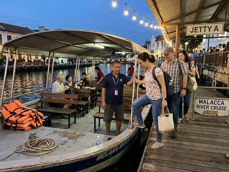 Guests boarding the river cruise boat at the jetty in the evening